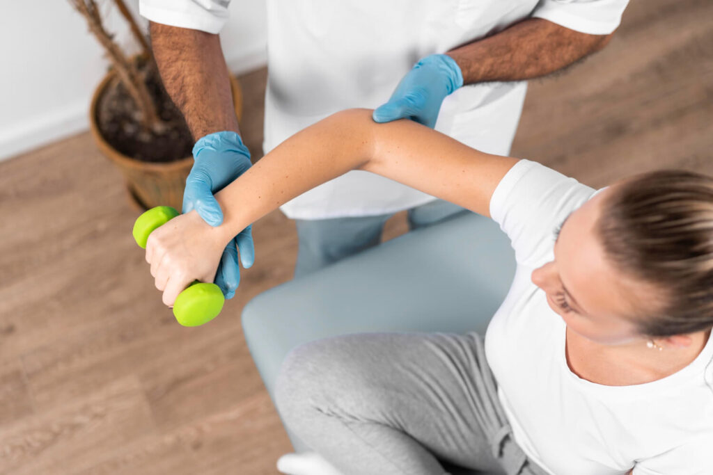 un physio qui aide une femme avec sa rééducation du coude et ses exercices