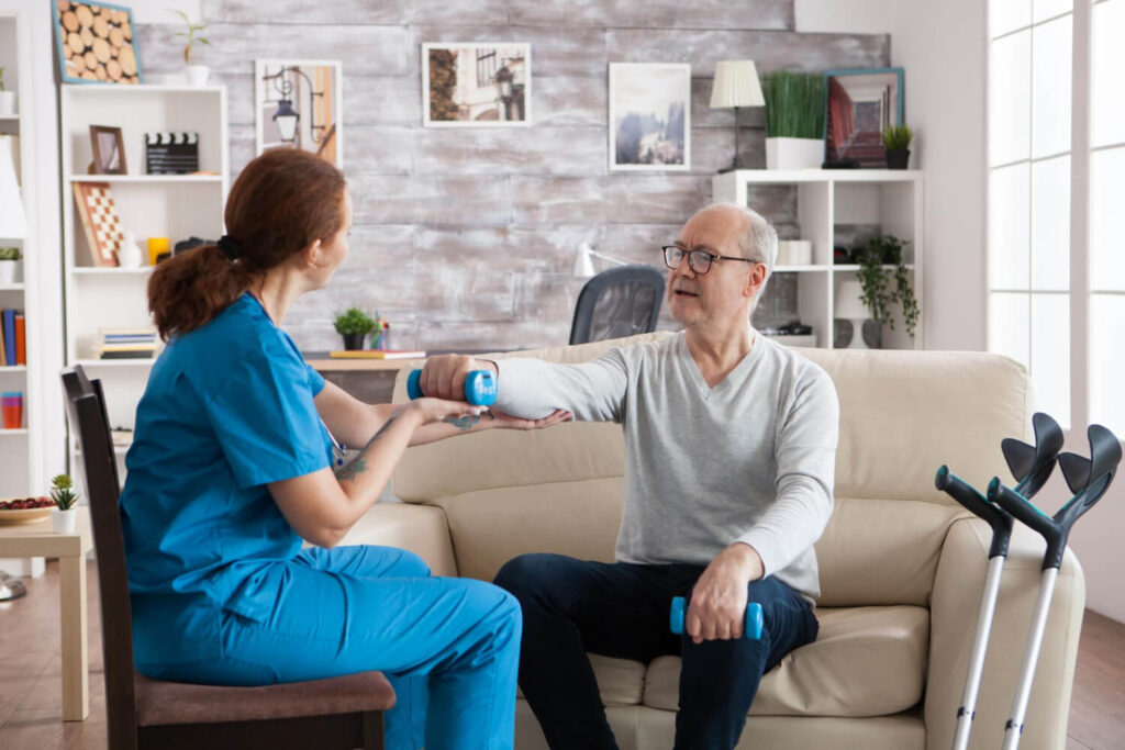 une physio aide un homme à faire ses exercices de rééducation du coude